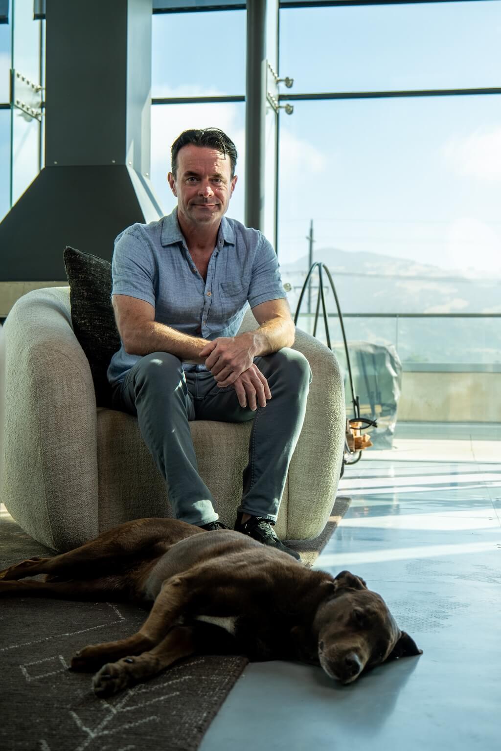 Douglas Keane with his dog Roxie laying in front of him.